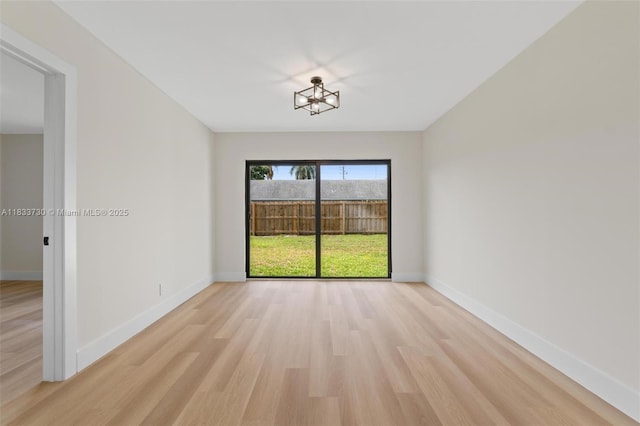 1340 SW 27th Pl, Boynton Beach, FL 33426 - empty room featuring light wood-style flooring and a chandelier