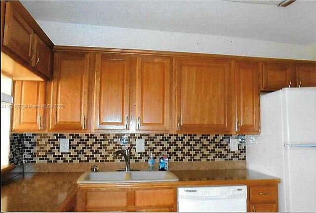 7900 Camino Crk Unit 401, Miami, FL 33143 - kitchen featuring dishwasher, freestanding refrigerator, decorative backsplash, and brown cabinetry