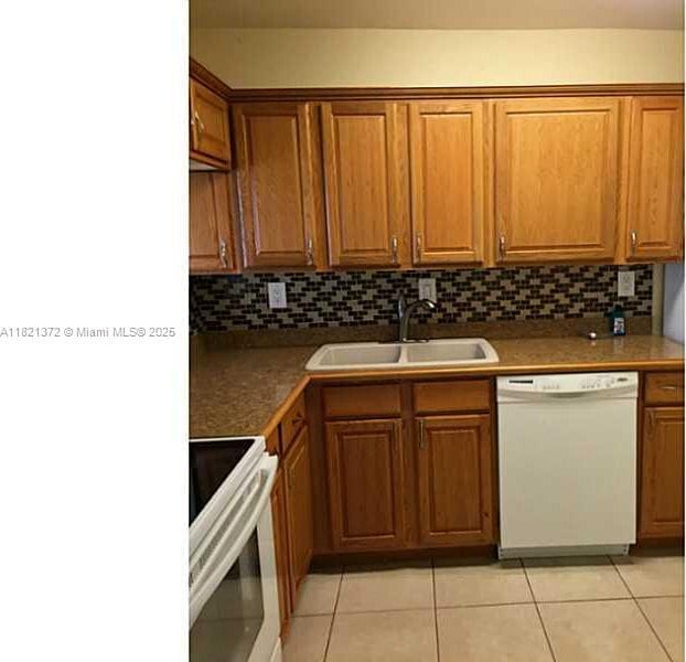 7900 Camino Crk Unit 401, Miami, FL 33143 - kitchen featuring white appliances, brown cabinets, light tile patterned floors, and tasteful backsplash