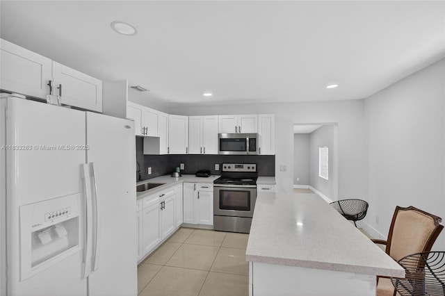 8224 NW 1st Pl, Miami, FL 33150 - kitchen with stainless steel appliances, a kitchen island, recessed lighting, white cabinets, and backsplash