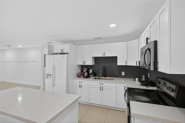 8224 NW 1st Pl, Miami, FL 33150 - kitchen featuring range with electric cooktop, white refrigerator with ice dispenser, stainless steel microwave, decorative backsplash, and white cabinetry