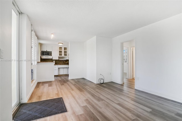2400 NE 9th St Unit 201, Fort Lauderdale, FL 33304 - unfurnished living room with light wood-style flooring and baseboards