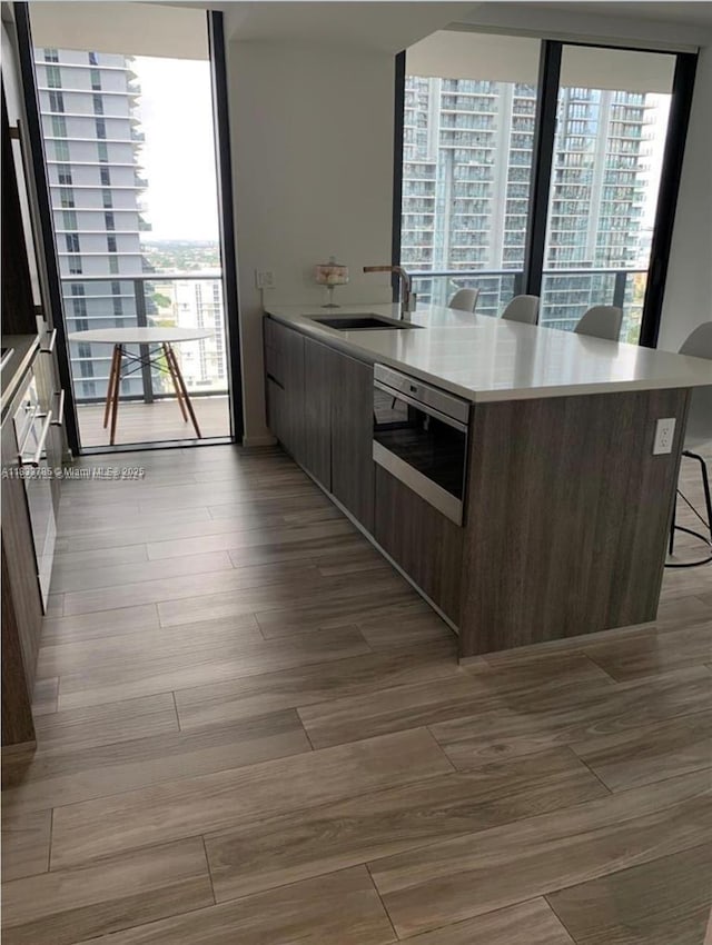801 S Miami Ave Unit 2609, Miami, FL 33130 - kitchen featuring modern cabinets, a kitchen bar, light countertops, and dark wood-style flooring