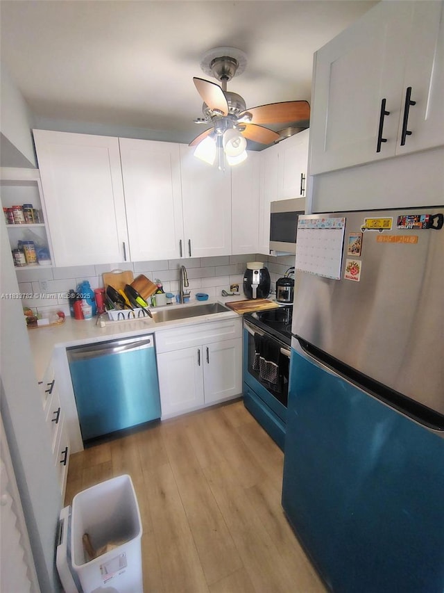 3716 NE 168th St Unit 303, North Miami Beach, FL 33160 - kitchen with stainless steel appliances, decorative backsplash, white cabinets, ceiling fan, and light wood-type flooring