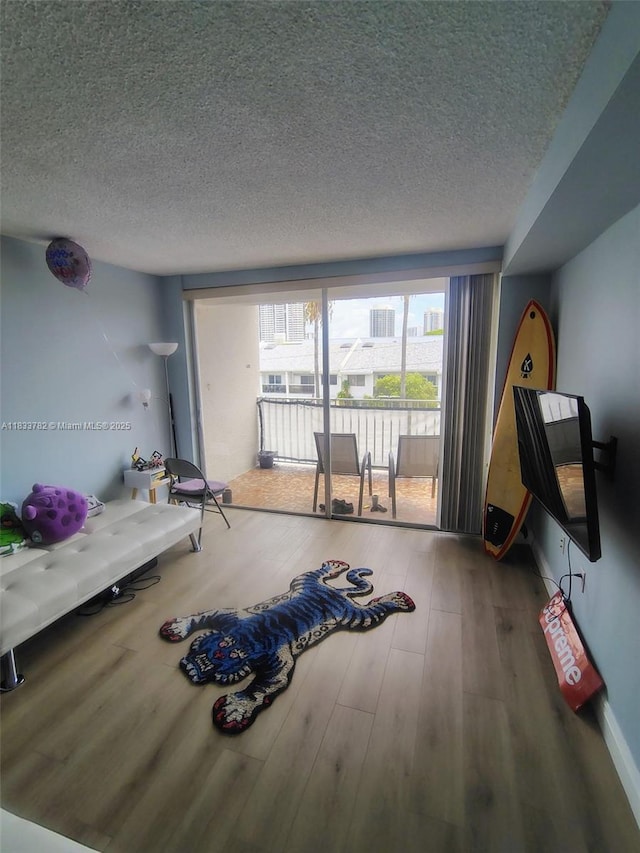 3716 NE 168th St Unit 303, North Miami Beach, FL 33160 - living area featuring a textured ceiling and wood finished floors