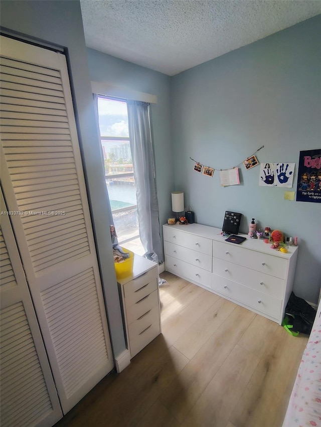 3716 NE 168th St Unit 303, North Miami Beach, FL 33160 - bedroom featuring light wood-style flooring and a textured ceiling