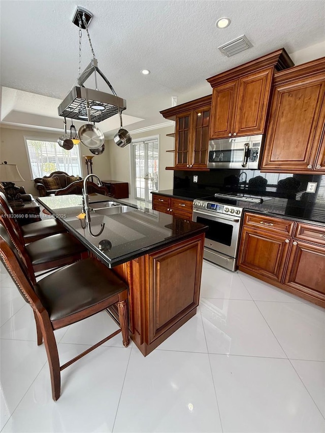 14601 SW 30th St, Miami, FL 33175 - kitchen featuring appliances with stainless steel finishes, brown cabinetry, backsplash, a breakfast bar, and a textured ceiling