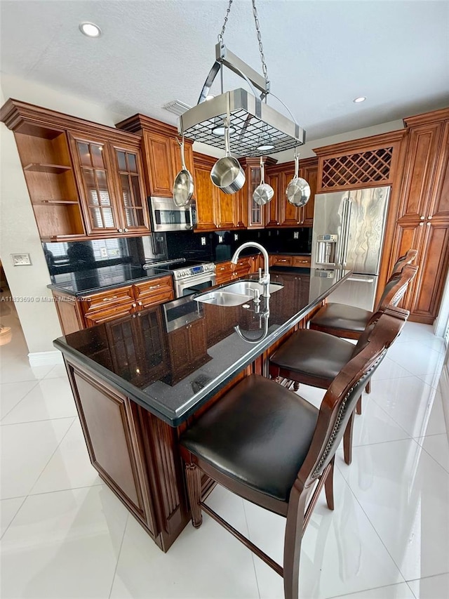 14601 SW 30th St, Miami, FL 33175 - kitchen featuring stainless steel appliances, brown cabinets, tasteful backsplash, a center island with sink, and recessed lighting