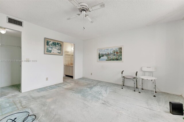 10304 Sunrise Lakes Blvd Unit 209, Sunrise, FL 33322 - unfurnished bedroom featuring light carpet, a textured ceiling, a ceiling fan, a walk in closet, and ensuite bathroom