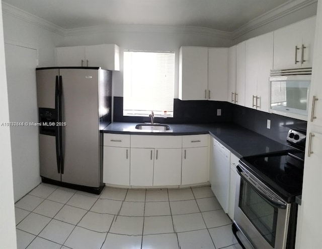 2025 NE 164th St Unit 516, North Miami Beach, FL 33162 - kitchen with appliances with stainless steel finishes, dark countertops, white cabinets, and ornamental molding