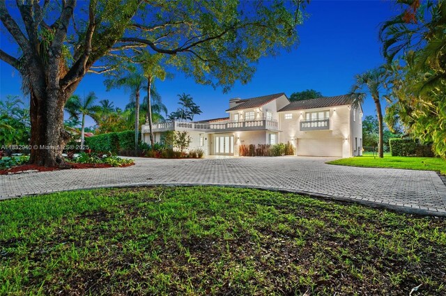 8250 SW 187th St, Cutler Bay, FL 33157 - mediterranean / spanish home with a balcony, curved driveway, a garage, a front yard, and french doors