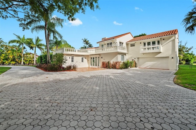 8250 SW 187th St, Cutler Bay, FL 33157 - mediterranean / spanish-style house featuring an attached garage, a balcony, decorative driveway, stucco siding, and french doors
