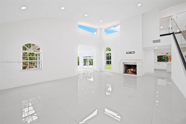 8250 SW 187th St, Cutler Bay, FL 33157 - unfurnished living room with a fireplace, recessed lighting, arched walkways, tile patterned floors, and high vaulted ceiling