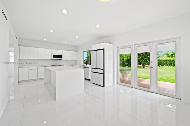 8250 SW 187th St, Cutler Bay, FL 33157 - kitchen featuring modern cabinets, light tile patterned floors, freestanding refrigerator, white cabinetry, and light countertops