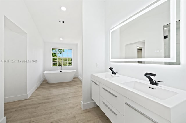 8250 SW 187th St, Cutler Bay, FL 33157 - bathroom featuring double vanity, a soaking tub, wood finished floors, and recessed lighting