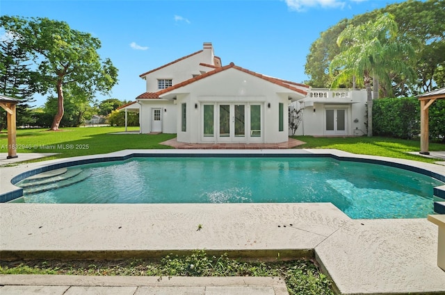 8250 SW 187th St, Cutler Bay, FL 33157 - back of house with a lawn, french doors, an outdoor pool, and a tiled roof
