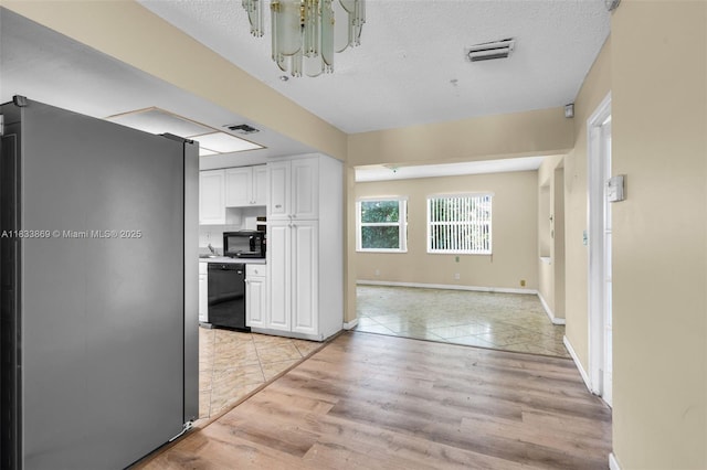 2727 Hypoluxo Rd, Boynton Beach, FL 33462 - kitchen featuring black appliances, white cabinets, a chandelier, light wood-type flooring, and a textured ceiling