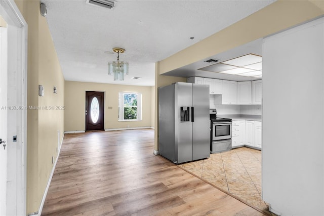 2727 Hypoluxo Rd, Boynton Beach, FL 33462 - kitchen featuring appliances with stainless steel finishes, light wood-type flooring, a chandelier, white cabinetry, and hanging light fixtures
