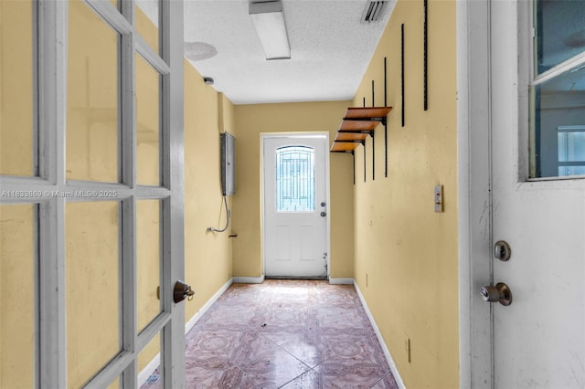 2727 Hypoluxo Rd, Boynton Beach, FL 33462 - doorway to outside with a textured ceiling and light tile patterned floors