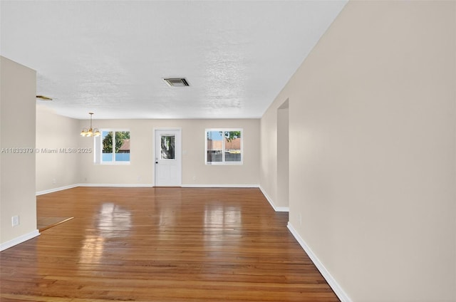 4061 Nova Ln, Lake Worth, FL 33462 - empty room featuring hardwood / wood-style floors, a chandelier, and a textured ceiling