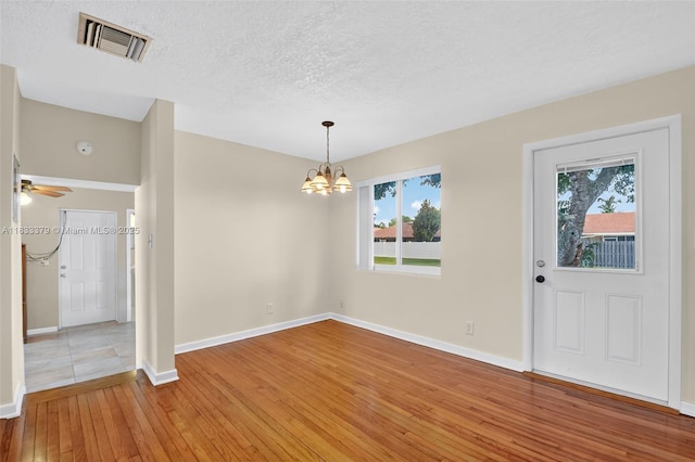4061 Nova Ln, Lake Worth, FL 33462 - unfurnished room with light wood-type flooring, a chandelier, a textured ceiling, and a ceiling fan