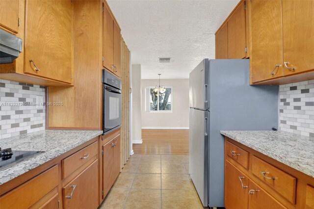 4061 Nova Ln, Lake Worth, FL 33462 - kitchen featuring wall oven, light tile patterned floors, tasteful backsplash, brown cabinets, and a textured ceiling