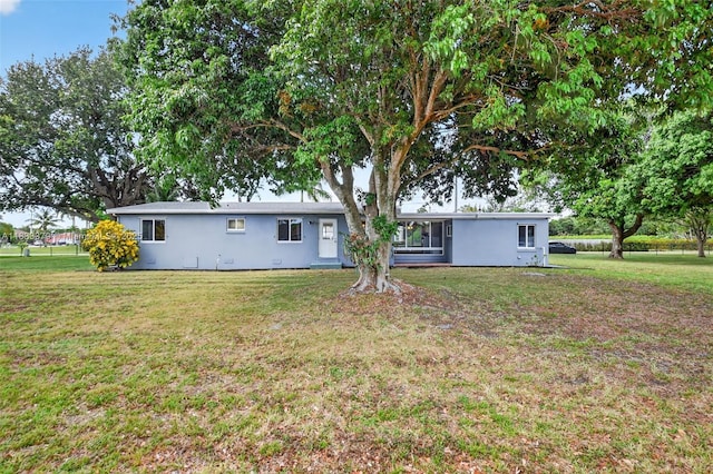 4061 Nova Ln, Lake Worth, FL 33462 - back of house featuring stucco siding and a lawn