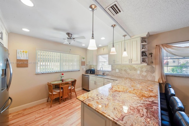 841 Meadowlark Ln, Delray Beach, FL 33445 - kitchen with appliances with stainless steel finishes, open shelves, decorative backsplash, light wood-type flooring, and a ceiling fan