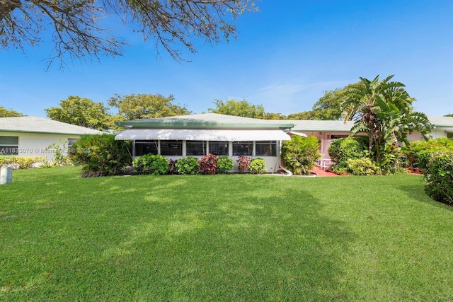 841 Meadowlark Ln, Delray Beach, FL 33445 - rear view of house featuring a yard and a sunroom