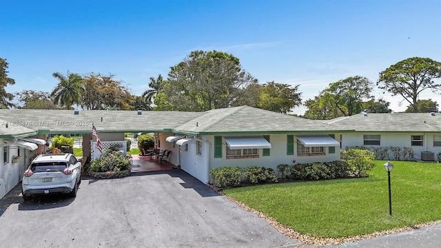 841 Meadowlark Ln, Delray Beach, FL 33445 - ranch-style house with a front lawn, asphalt driveway, an attached carport, and stucco siding