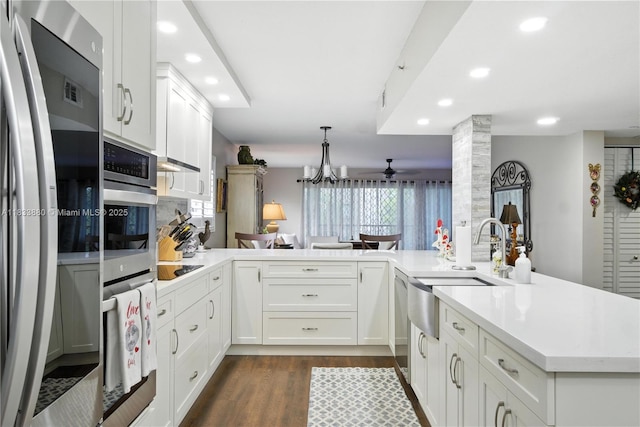 1651 SW 127th Ave Unit 301A, Pembroke Pines, FL 33027 - kitchen with appliances with stainless steel finishes, a peninsula, recessed lighting, dark wood finished floors, and light countertops