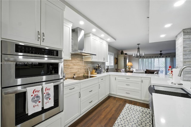 1651 SW 127th Ave Unit 301A, Pembroke Pines, FL 33027 - kitchen featuring stainless steel double oven, wall chimney range hood, black electric cooktop, recessed lighting, and decorative backsplash