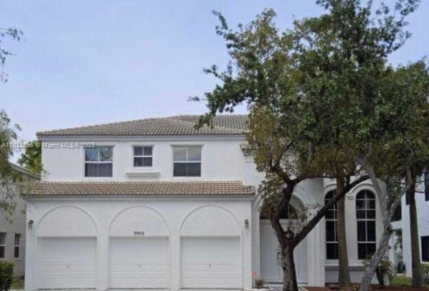 5052 SW 167th Ave, Miramar, FL 33027 - view of front of property featuring a garage, a tiled roof, driveway, and stucco siding