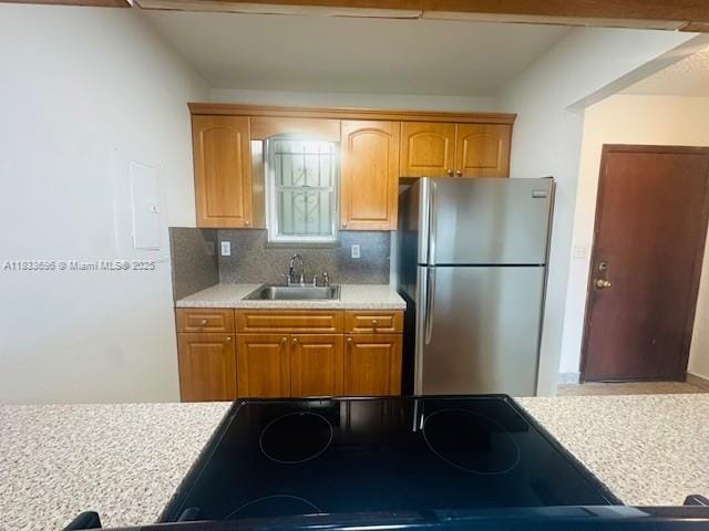 3181 SW 13th St Unit 307, Miami, FL 33145 - kitchen featuring freestanding refrigerator, light countertops, tasteful backsplash, brown cabinetry, and stovetop
