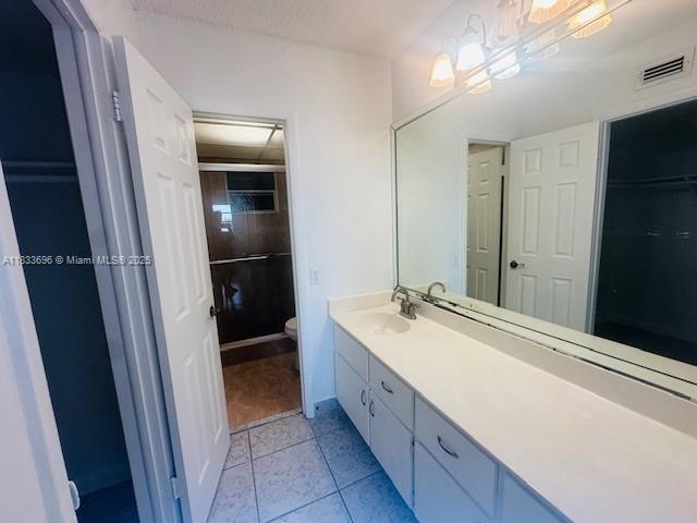 3181 SW 13th St Unit 307, Miami, FL 33145 - bathroom with vanity, tile patterned flooring, and a shower with door