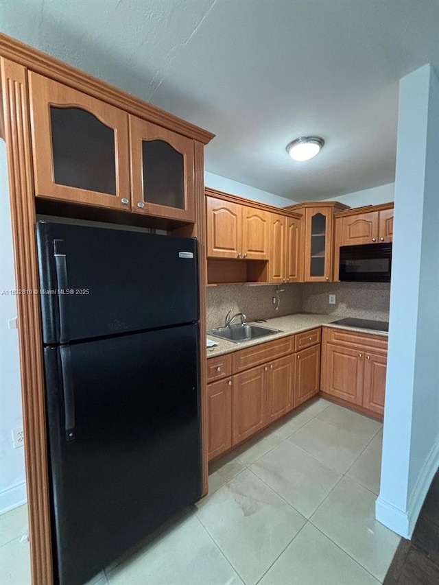 1860 Venice Park Dr Unit 110, North Miami, FL 33181 - kitchen featuring black appliances, glass insert cabinets, light countertops, backsplash, and light tile patterned floors