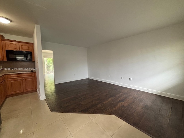 1860 Venice Park Dr Unit 110, North Miami, FL 33181 - kitchen with black appliances, wood finished floors, brown cabinetry, and open floor plan