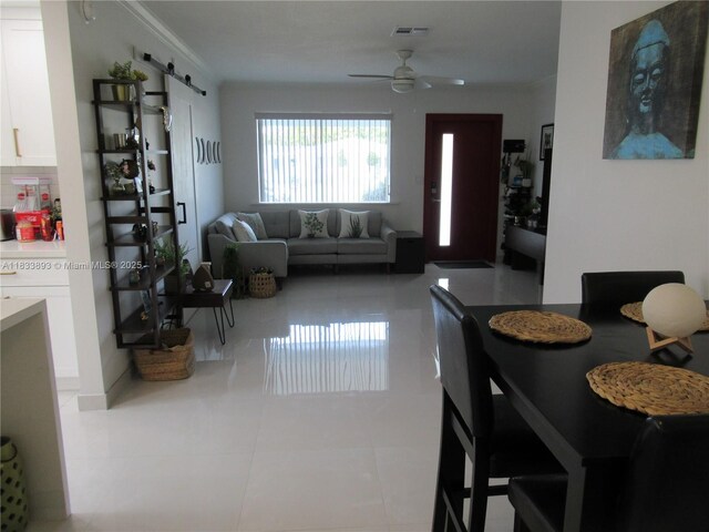 6910 SW 26th Ct, Miramar, FL 33023 - tiled dining space featuring ceiling fan, a barn door, and ornamental molding