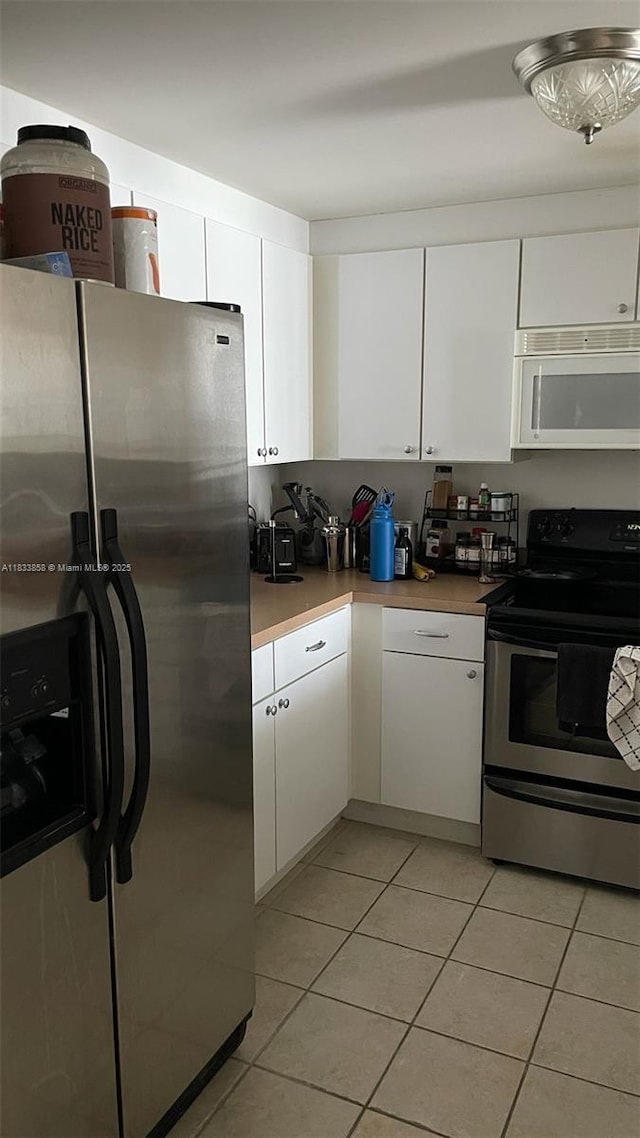 1250 S Miami Ave Unit 1209, Miami, FL 33130 - kitchen featuring stainless steel appliances, light tile patterned floors, and white cabinets