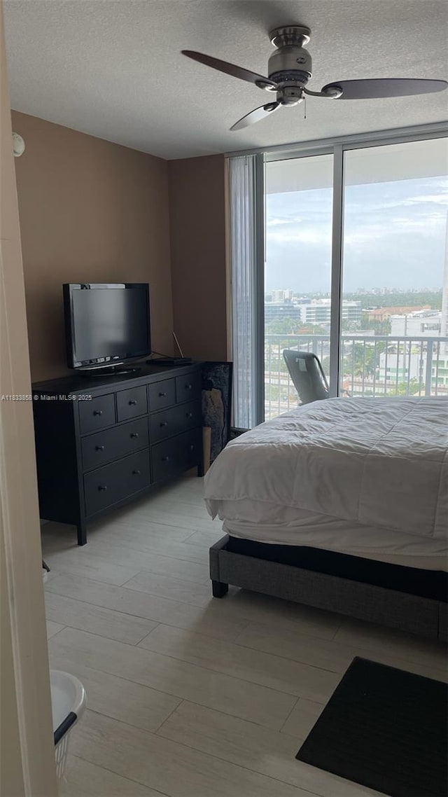 1250 S Miami Ave Unit 1209, Miami, FL 33130 - bedroom featuring access to exterior, a ceiling fan, a textured ceiling, and light wood-style flooring