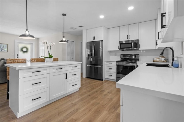 9360 SW 185th St, Cutler Bay, FL 33157 - kitchen featuring appliances with stainless steel finishes, light wood finished floors, pendant lighting, a kitchen island, and light countertops