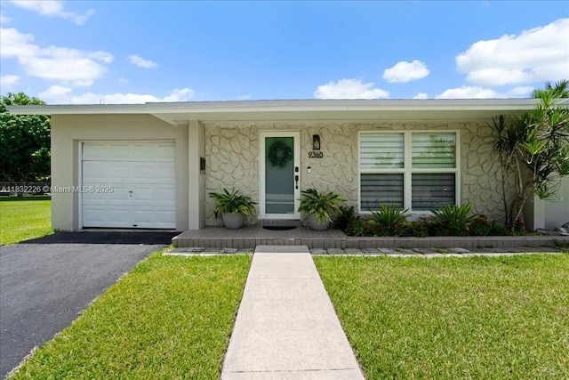 9360 SW 185th St, Cutler Bay, FL 33157 - view of front facade with a front lawn, a garage, asphalt driveway, and stucco siding