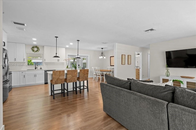 9360 SW 185th St, Cutler Bay, FL 33157 - living room with light wood-style floors, recessed lighting, and a chandelier