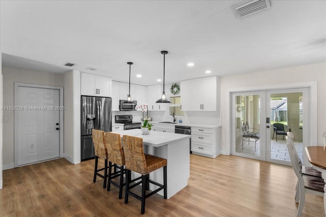 9360 SW 185th St, Cutler Bay, FL 33157 - kitchen featuring stainless steel appliances, french doors, a breakfast bar, white cabinets, and recessed lighting