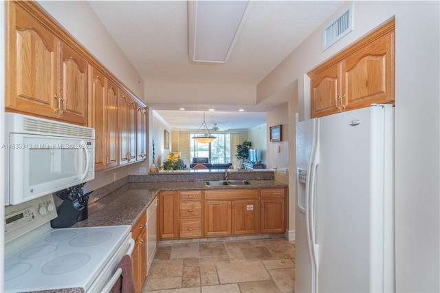 101 Gulfview Dr Unit 202, Key Colony, FL 33036 - kitchen featuring white appliances, stone tile floors, dark stone counters, brown cabinetry, and hanging light fixtures