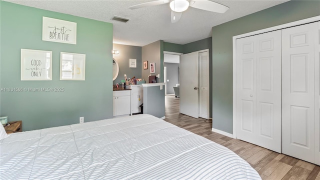 1226 SW Curry St, Port St Lucie, FL 34983 - bedroom featuring wood finished floors, two closets, ceiling fan, and a textured ceiling