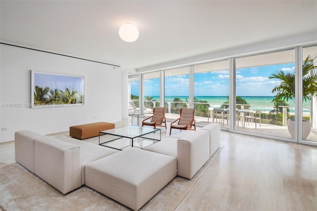 9001 Collins Ave Unit S-305, Surfside, FL 33154 - living area with expansive windows, light wood finished floors, and a water view
