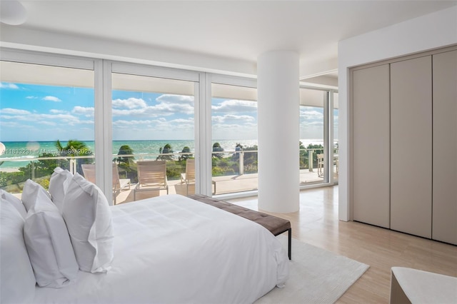 9001 Collins Ave Unit S-305, Surfside, FL 33154 - bedroom with light wood-style flooring, a water view, and floor to ceiling windows