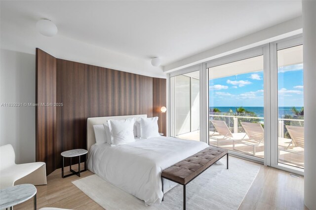 9001 Collins Ave Unit S-305, Surfside, FL 33154 - bedroom featuring access to outside, multiple windows, a water view, and light wood finished floors