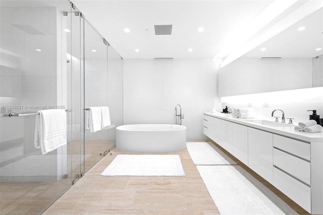 9001 Collins Ave Unit S-305, Surfside, FL 33154 - bathroom featuring double vanity, a freestanding tub, a shower stall, and recessed lighting